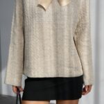Beige knit sweater with a satin bow at the neckline
